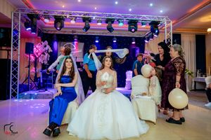 Wedding celebration space with white chairs and dramatic blue and purple stage lighting.
