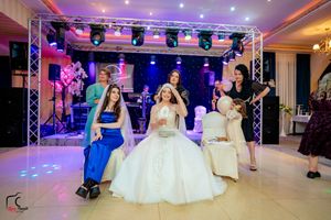 Formal event space featuring theatrical lighting and elegant white party setup.