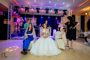 Wedding venue with professional stage lighting and formal white seating arrangements.
