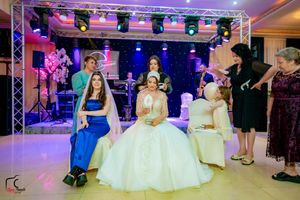 Event space decorated with professional lighting and formal white seating for a special occasion.