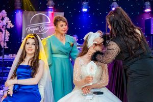 Wedding party members dancing and celebrating in a beautifully lit reception venue.