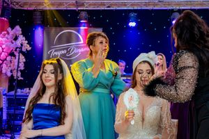 Wedding guests enjoying the dance floor under dramatic blue and purple stage lighting.