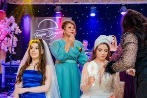 Wedding reception featuring guests dancing and celebrating under dramatic stage lighting.