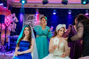 Wedding party members dancing and socializing at an elegantly lit indoor reception venue.