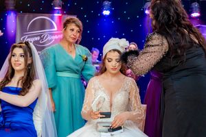Wedding party enjoying festivities under dramatic blue and purple venue lighting.