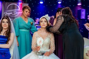 Wedding celebration with guests in formal attire under blue and purple ambient lighting.