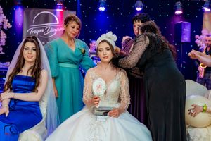 Wedding party gathering under dramatic stage lighting with sparkly backdrop and decorations.