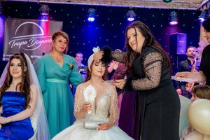 Wedding party gathering on dance floor with dramatic blue lighting and decorative starry backdrop.