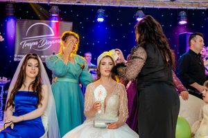 Wedding reception dance floor filled with guests under dramatic blue and purple venue lighting.
