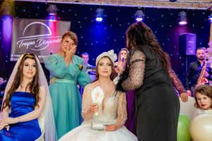 Lively wedding party scene with guests dancing under theatrical lighting and starry backdrop decor.