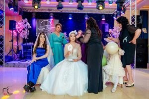 Wedding celebration showing dance floor activities with dramatic lighting and formal-dressed guests.