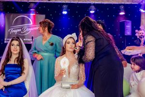 Wedding celebration in a ballroom with dramatic blue lighting and entertainment setup.