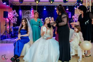 Elegant wedding reception venue with purple and blue mood lighting and guests enjoying the celebration.