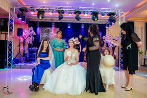 Elegant ballroom with colorful lighting and stage setup during a wedding celebration.