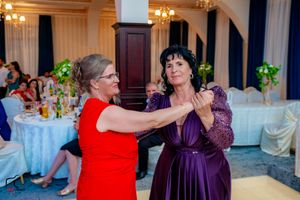Dance partners share a moment during a wedding reception in an elegant ballroom setting.