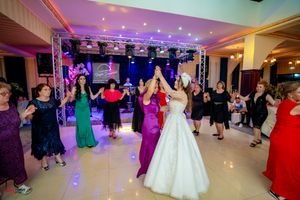 Panoramic view of wedding reception venue with vibrant lighting and large dance floor.