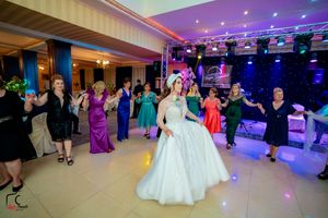 Spacious wedding venue with elegant lighting and guests enjoying the dance floor.