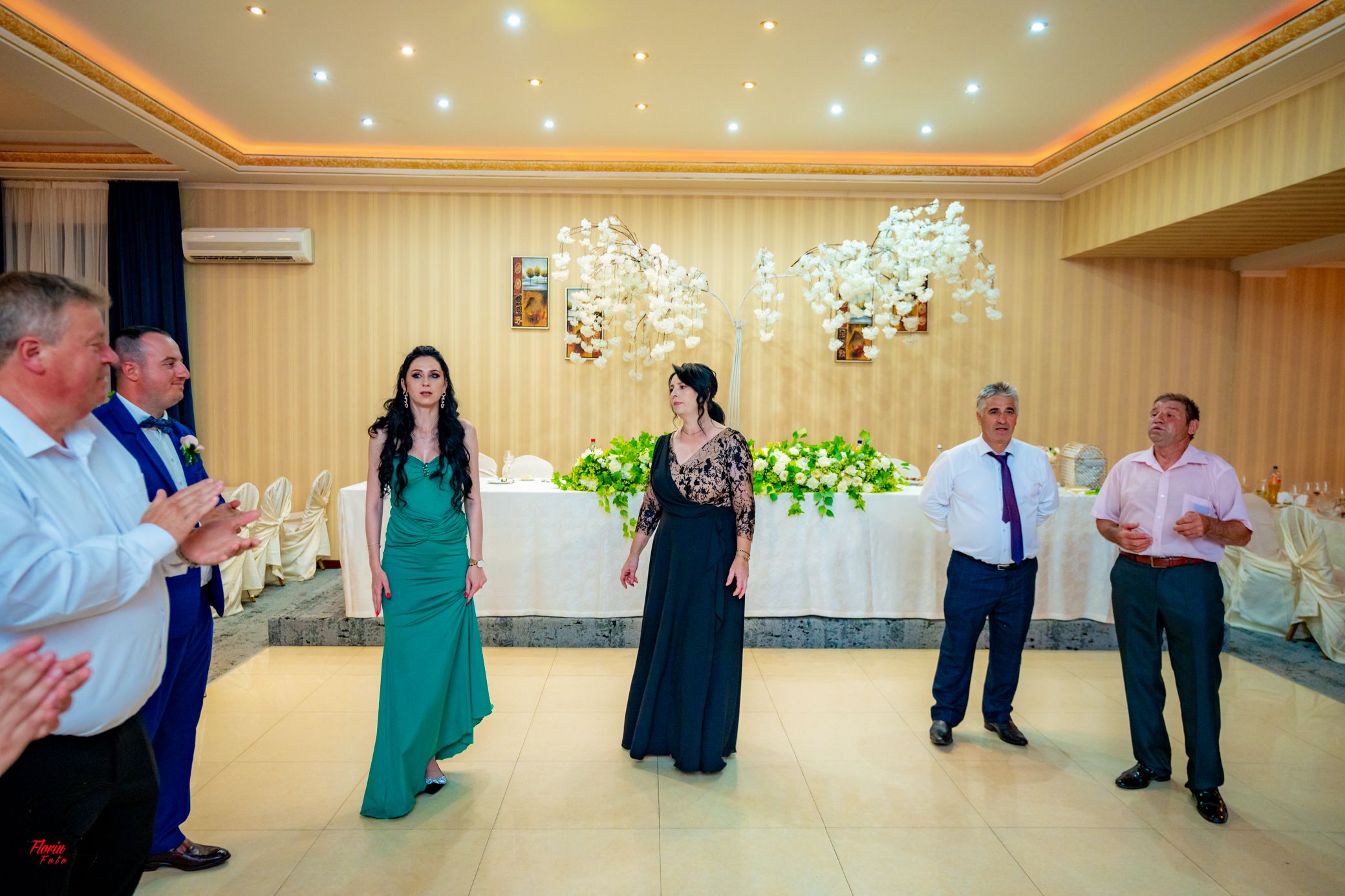 Guests enjoying a dance celebration in a well-lit banquet hall with elegant decor.