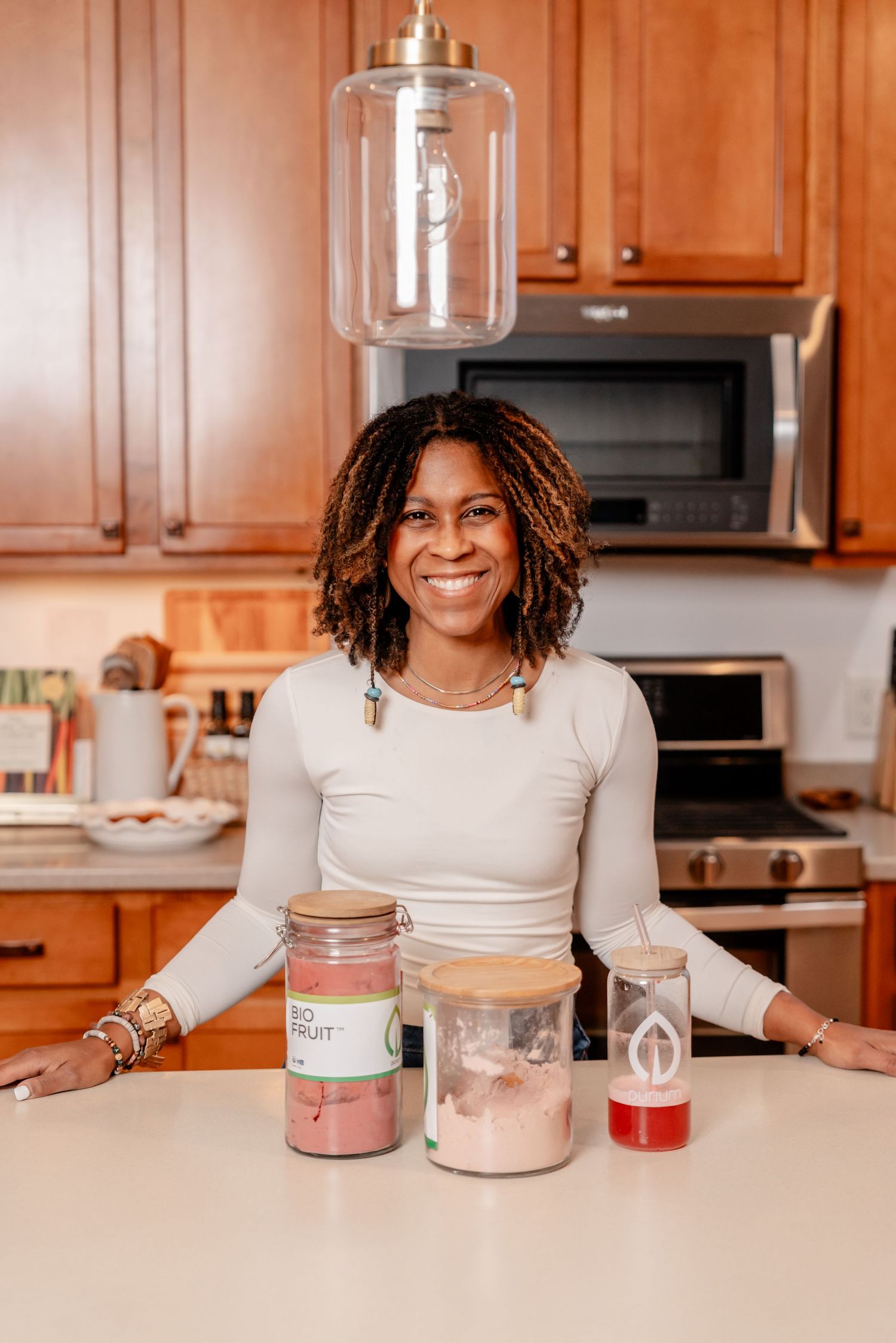 Mason jars with ingredients sit on white kitchen counter with warm wooden cabinets and stainless steel appliances in background.
