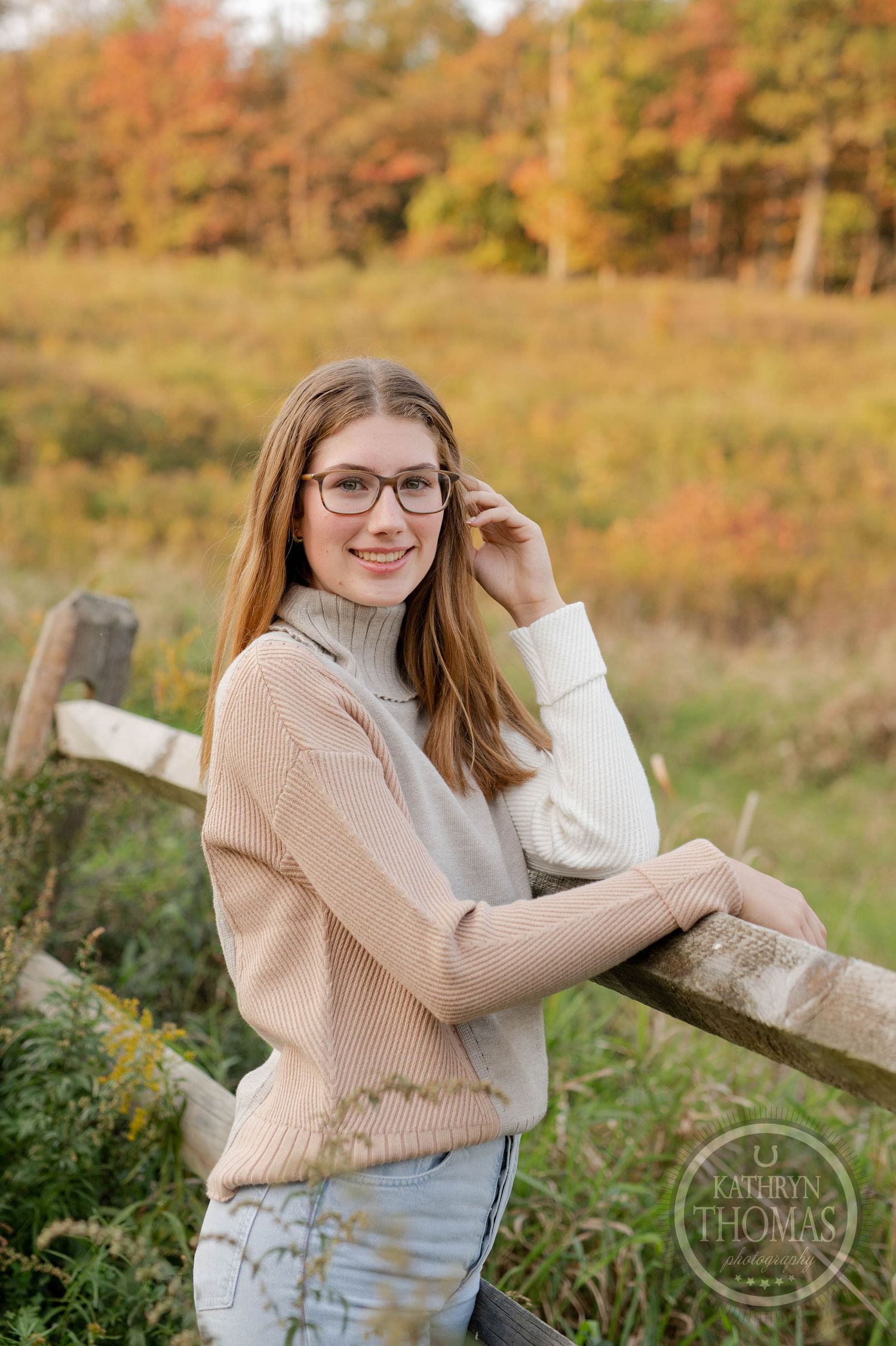 Natural autumn portrait with beige cardigan and turtleneck against golden field backdrop.