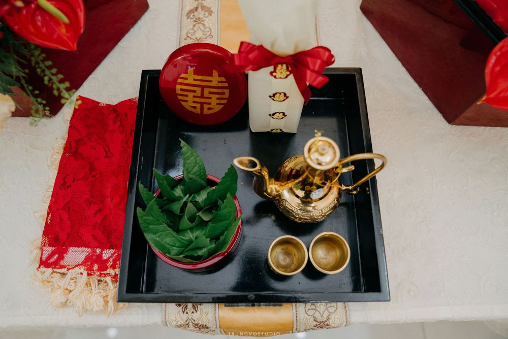 Golden teapot and cups on a black tray with double happiness symbol for a Chinese tea ceremony.