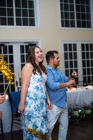 Guests enjoying a dance party at a wedding reception in a bright indoor venue.