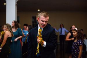 Guests dancing and celebrating at a lively wedding reception indoors.