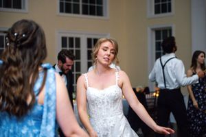 Wedding reception dance floor with guests in formal attire and blue dresses.