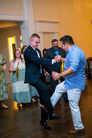 Dynamic dance moves being performed by guests at a wedding celebration.