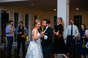 Wedding reception dance floor with guests celebrating under warm lighting.