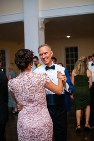 Couples dancing together at an elegant indoor wedding reception.