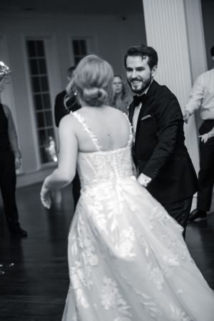 Black and white photo of newlyweds dancing together at their reception.