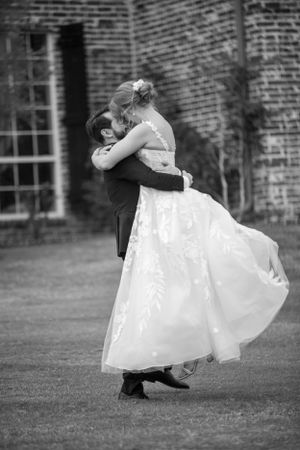 Black and white photo of a romantic wedding dance on a lawn.