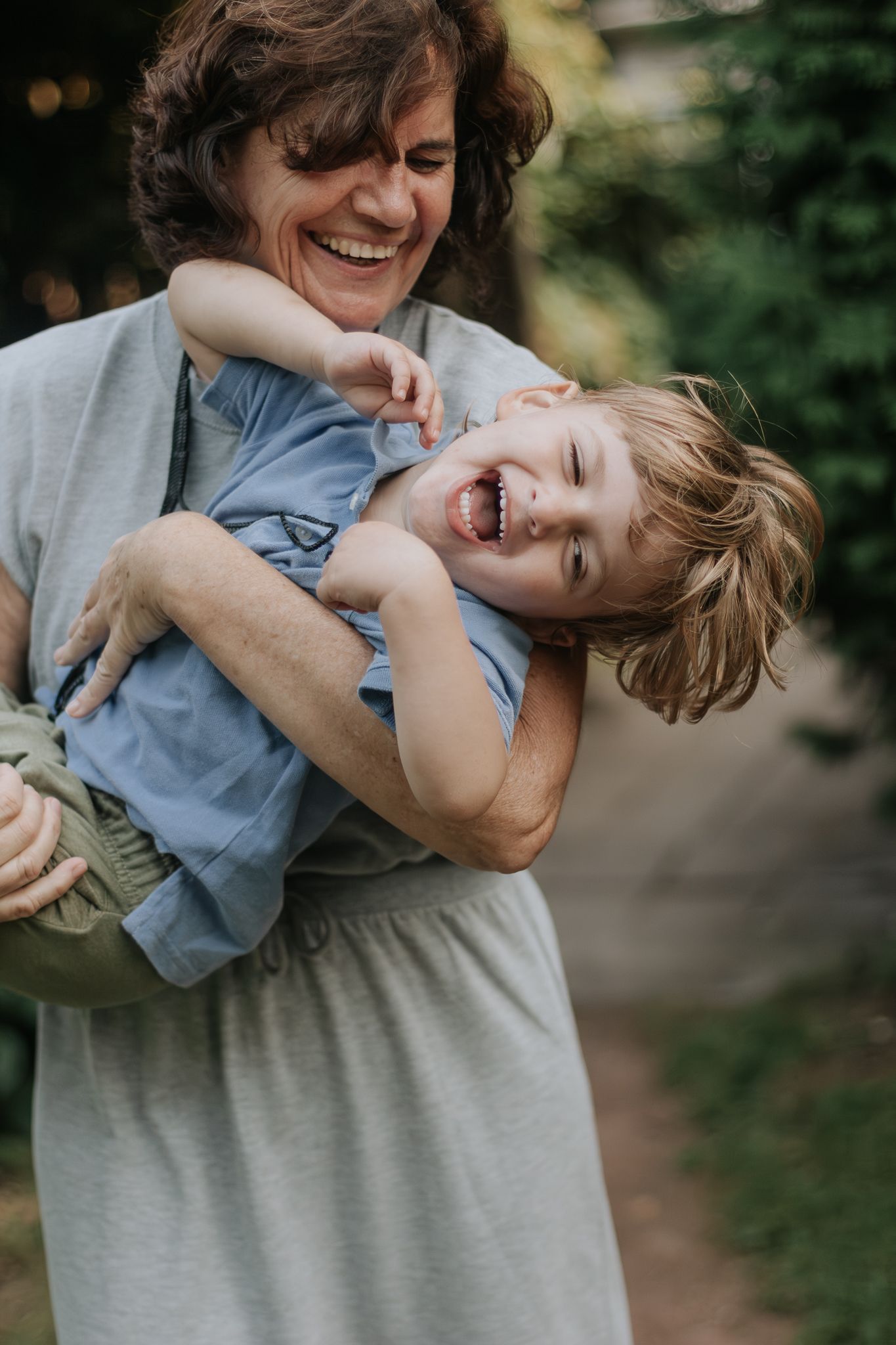 grandmother carrying her grandson and having fun with his smile at the park In Toronto