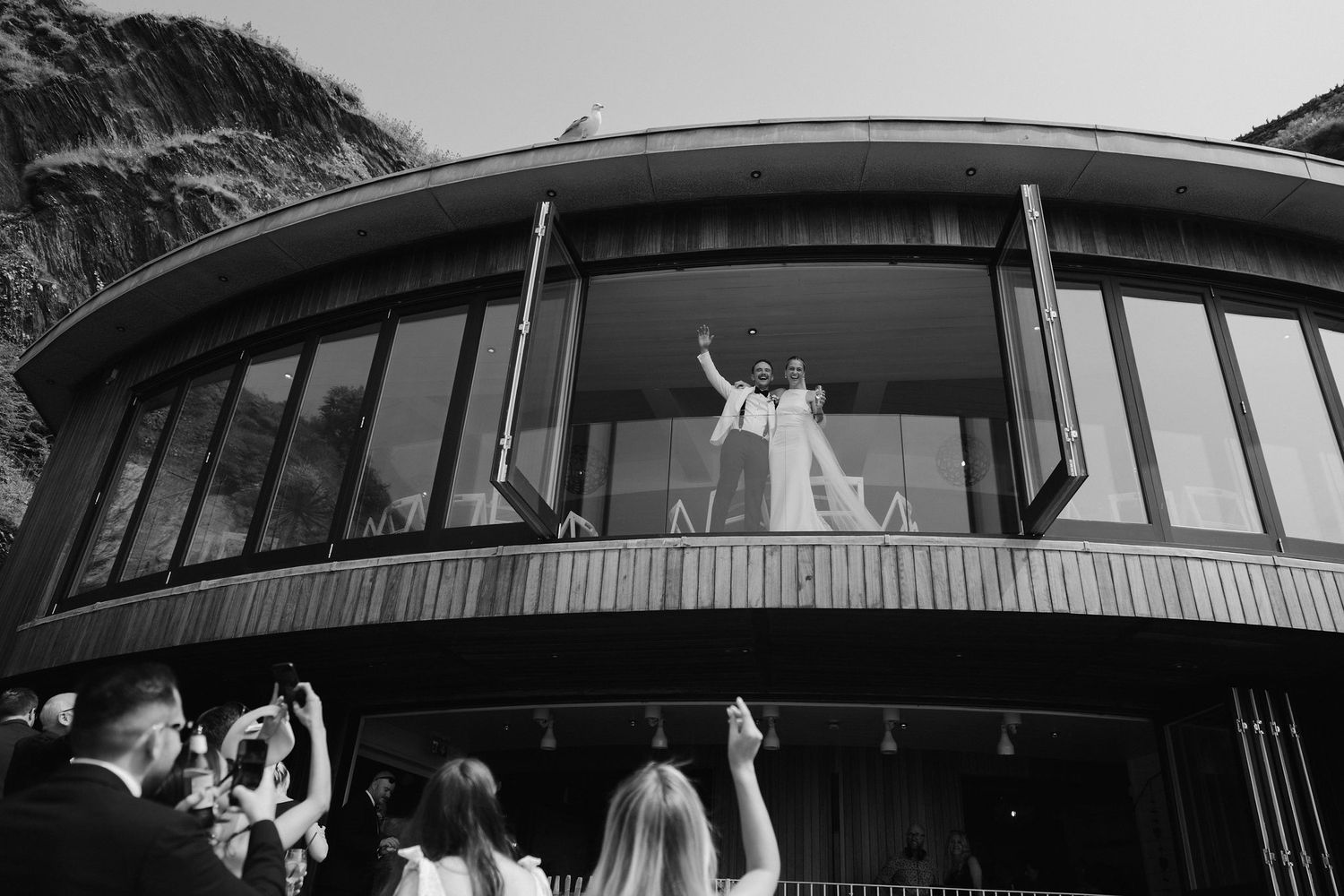 Bride and Groom celebrating drinks reception at Tunnels Beach wedding venue in north Devon