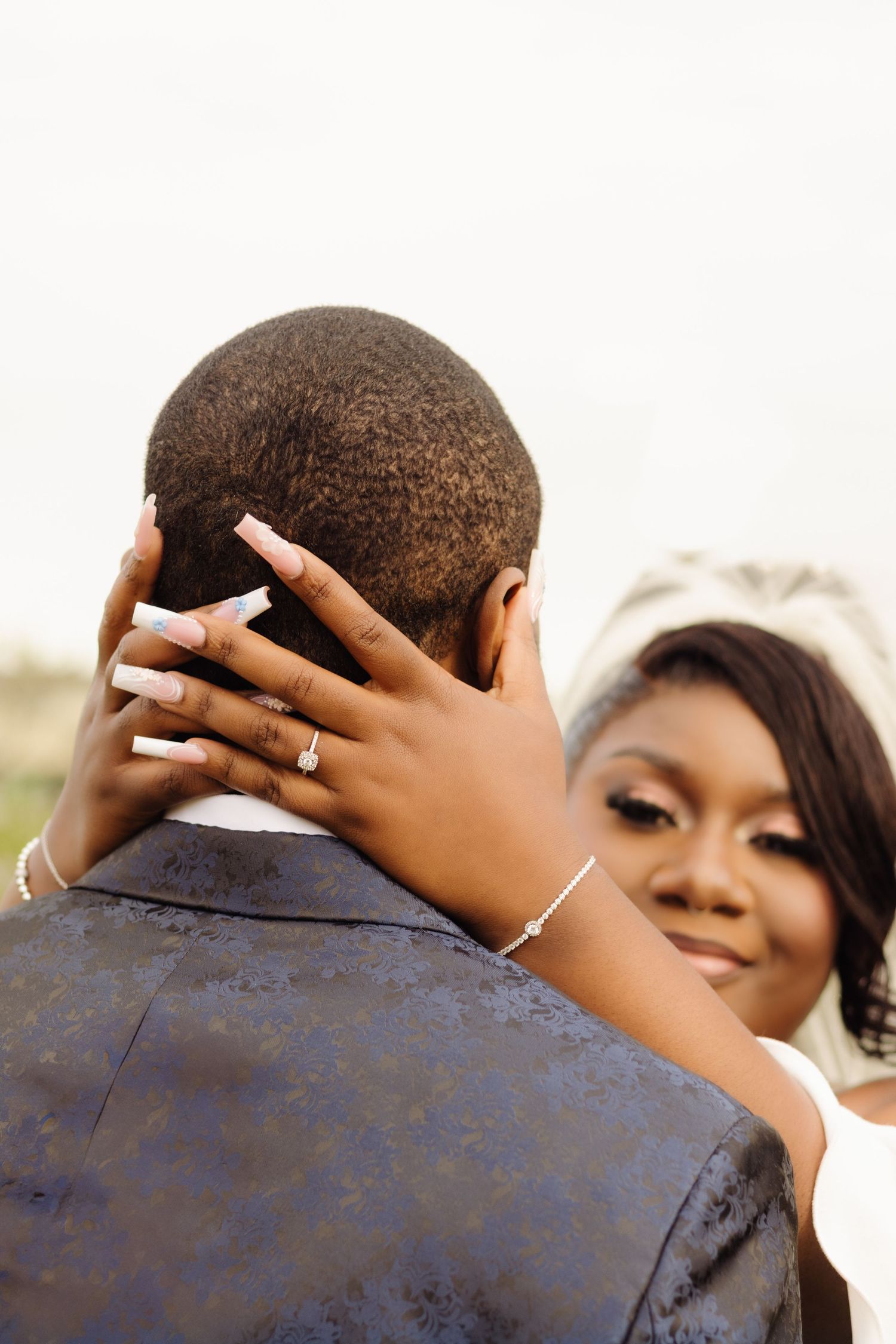 A romantic wedding moment showing hands lovingly embracing while wearing an elegant engagement ring.