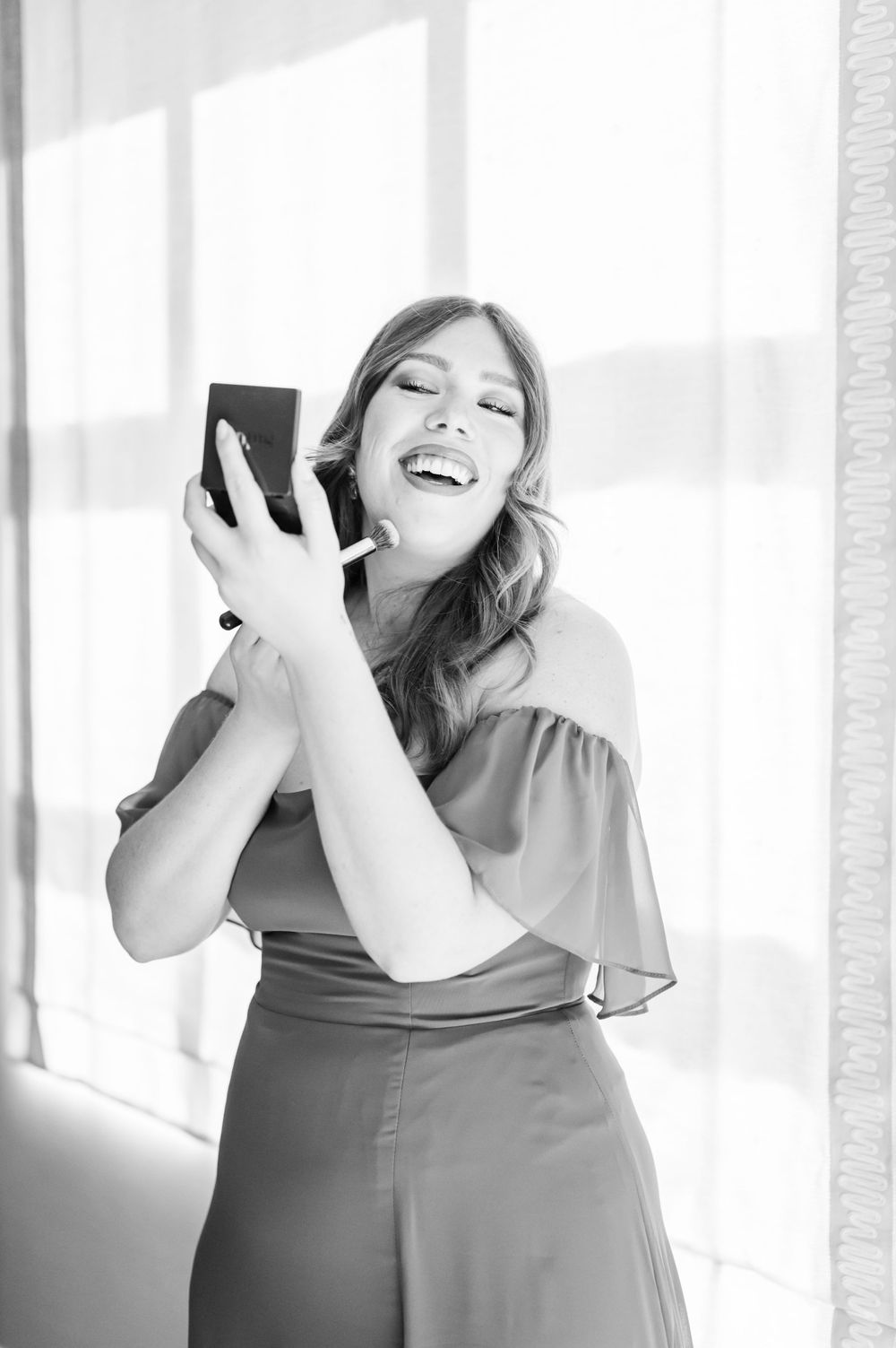 Bridesmaid puts on makeup at wedding at OSU's St. John Catholic Student Center in Stillwater, Oklahoma.