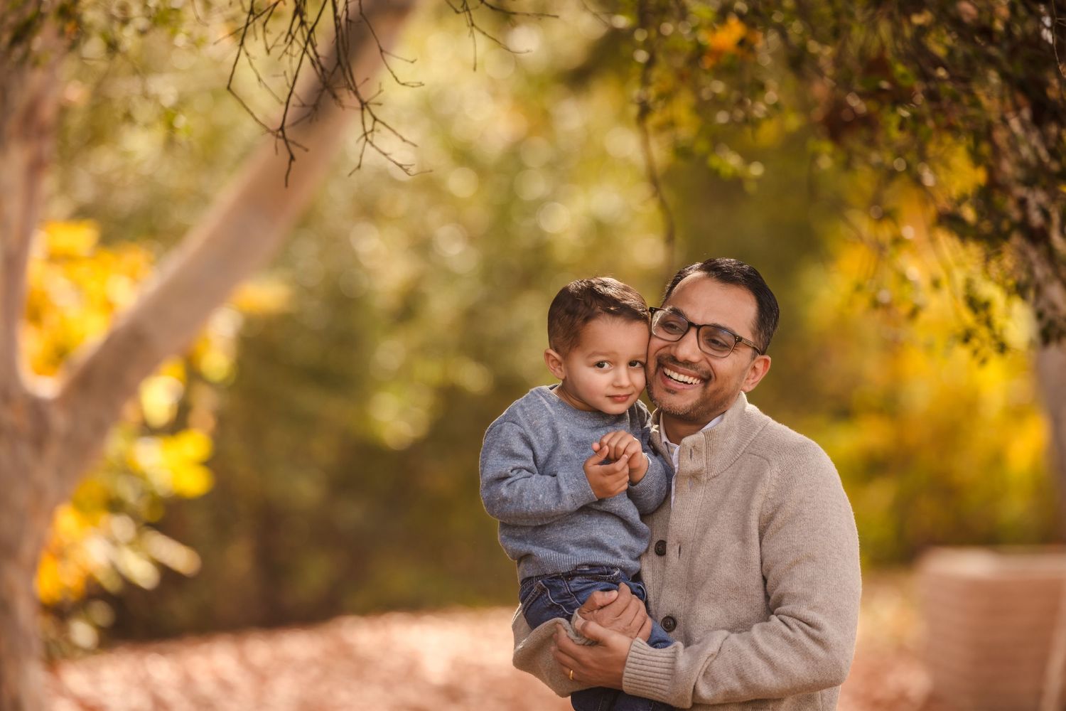 A heartwarming father-child moment under fall foliage.