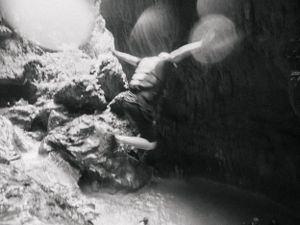 Black and white close-up of textured rock formations in a cave or cavern.