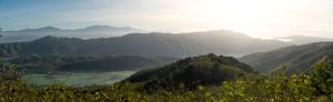 Panoramic view of mountain ranges stretching across the horizon at sunset.