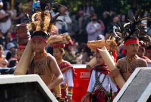 Crowd of festival-goers enjoying an outdoor summer celebration with colorful decorations.