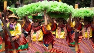 Vibrant festival performance featuring dancers in traditional green and red costumes.