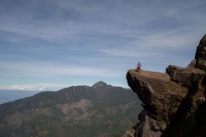 Rocky mountain overlook with dramatic views of distant peaks and valleys under blue skies.