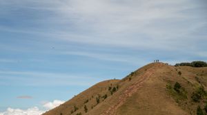 Panoramic mountain landscape with clear blue skies and grassy slopes stretching into the distance.