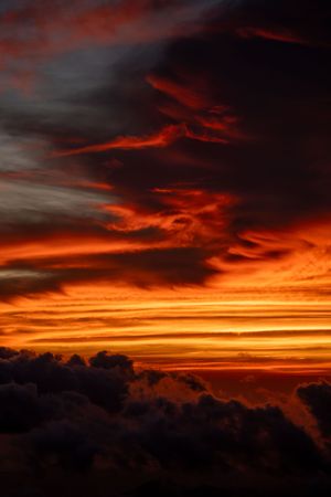 Dramatic red and orange clouds swirling in a fiery sunset sky.