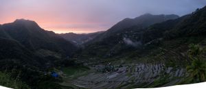 Panoramic view of mountains at sunset with pink and purple sky.
