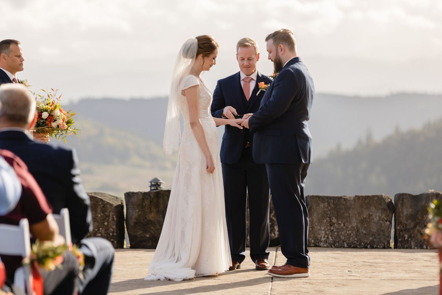 A couple exchanges vows during an outdoor mountain wedding ceremony with scenic views in the background.