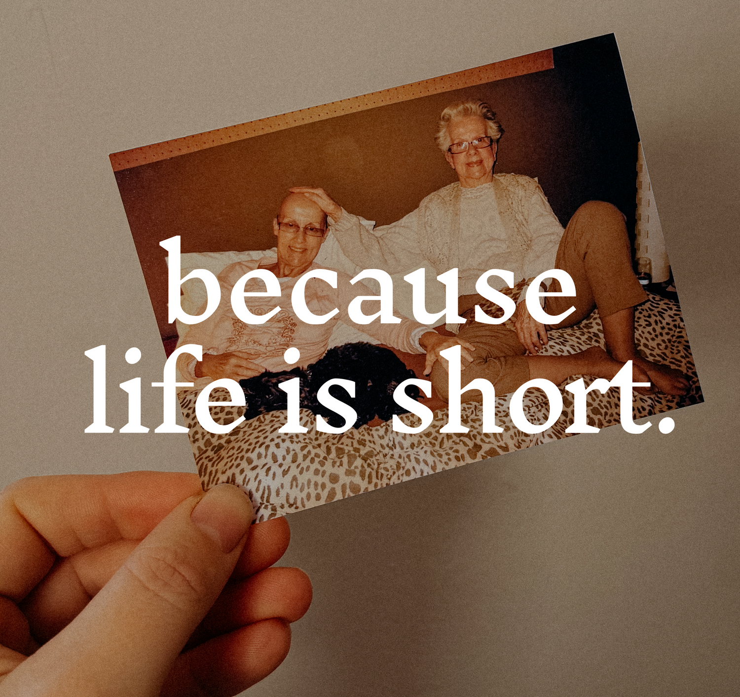Someone holding a vintage photo with overlaid text saying 'because life is short' in white letters.