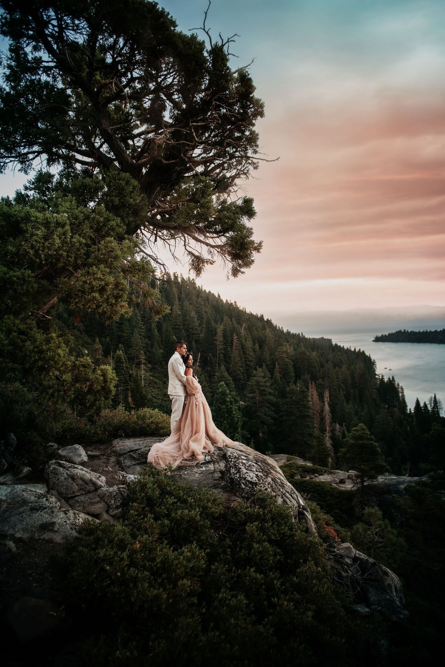 Lake Tahoe wedding photographer captures romantic sunset photoshoot – couple embraces on scenic mountain with lake views.