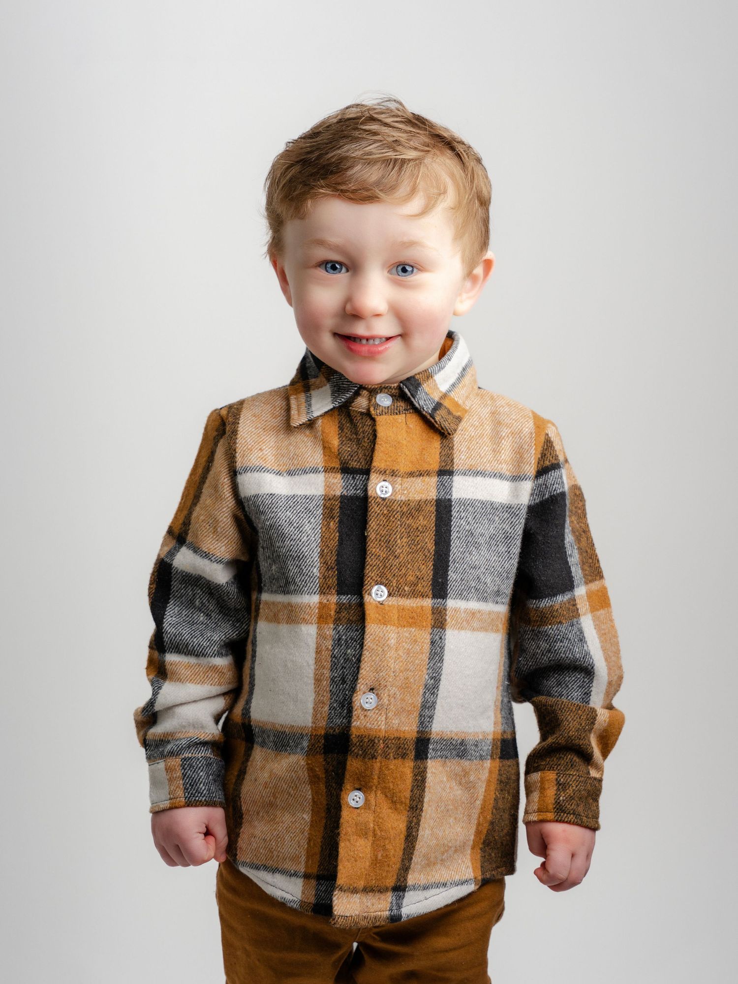 Photo of little boy with red hair in a plaid shirt in children's photography studio in Jefferson County Tennessee by family photographer
